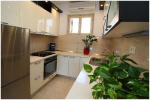 eine Küche mit weißen Schränken und einem Waschbecken in der Unterkunft Apartment Slavko in Primošten