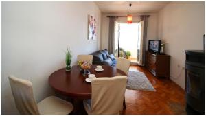 a living room with a table and chairs and a couch at Apartment Slavko in Primošten