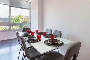 - une table à manger avec des chaises et des tasses rouges dans l'établissement Feel at home - Free private parking, à Braga