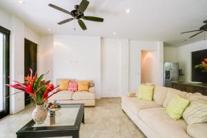 a living room with a couch and a ceiling fan at Makara Suite Mariposa Ground Floor in Uvita
