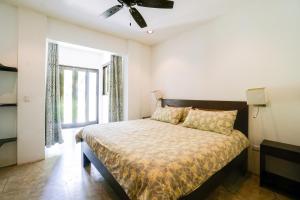 a bedroom with a bed and a ceiling fan at Makara Suite Mariposa Ground Floor in Uvita