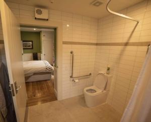 a bathroom with a toilet and a bed in a room at Waipara River Estate in Waipara