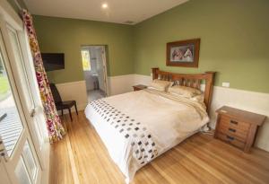 um quarto com uma cama grande e paredes verdes em Waipara River Estate em Waipara