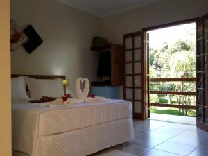 リンドーイアにあるPousada Mirante Do Lagoのベッドルーム1室(白いベッド1台、ドア付)