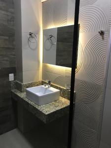 a bathroom with a sink and a mirror at Del Rio Apart Hotel in Encarnación