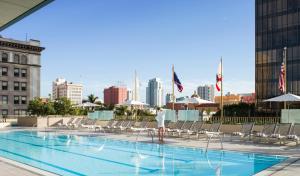 eine Person, die neben einem Pool in einem Gebäude steht in der Unterkunft The Westgate Hotel in San Diego