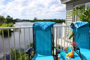 a balcony with a table and chairs with a view of the water at Latitude 26 Waterfront Boutique Resort - Bonita Springs in Bonita Springs