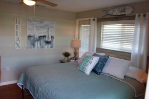 a bedroom with a bed with pillows and a window at Latitude 26 Waterfront Boutique Resort - Bonita Springs in Bonita Springs