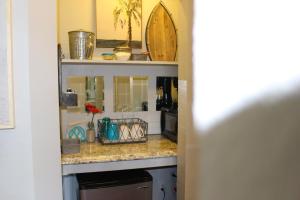 a kitchen counter with a sink and a surfboard on it at Latitude 26 Waterfront Boutique Resort - Bonita Springs in Bonita Springs