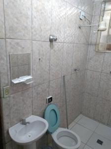 a bathroom with a blue toilet and a sink at Pousada Vitória in Aparecida