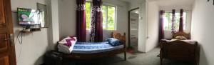 um quarto com uma cama num quarto com uma janela em Parvi Homestay em Darjeeling