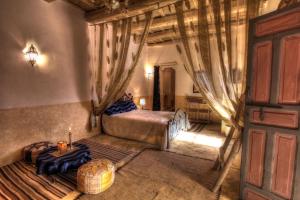 una camera da letto con un letto e una porta di legno di Jardin de la source a Aït Yous