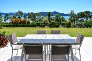 a table with chairs and a table cloth on it at Beach Lodges in Hamilton Island