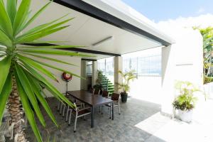 a patio with a wooden table and chairs and a plant at Cairns City Apartments in Cairns