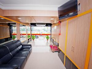 a living room with a couch and a flat screen tv at Hotel Bintang Indah in Kota Bharu