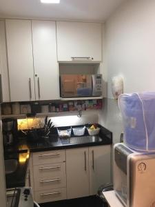 La cuisine est équipée de placards blancs et d'un four micro-ondes. dans l'établissement Ipanema Joa 510, à Rio de Janeiro