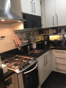 cocina con fogones y fregadero en Ipanema Joa 510, en Río de Janeiro