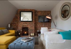 a living room with a couch and a brick wall at The Loft Midhurst in Midhurst