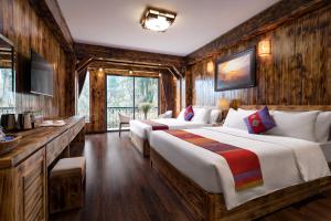 two beds in a room with wooden walls at The View Sapa Hotel in Sapa