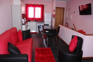 ヴィーラ・フランカ・ド・カンポにあるVila Centroのリビングルーム(赤いソファ、テーブル付)