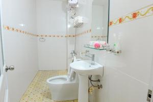 a white bathroom with a toilet and a sink at Tam Coc Tuan Minh Homestay in Ninh Binh