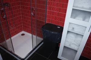 un bagno piastrellato rosso con doccia e cestino di Vila Centro a Vila Franca do Campo