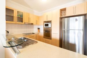 a large kitchen with a stainless steel refrigerator at Cairns City Apartments in Cairns