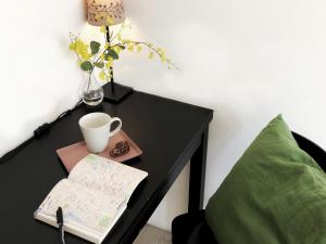 a table with a cup of coffee on top of it at Ahiruyah Guesthouse in Kaohsiung