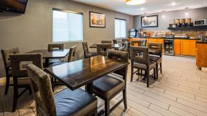 a restaurant with tables and chairs and a kitchen at SureStay by Best Western Kansas City Country Inn North in Kansas City