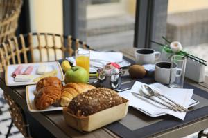 a table with a tray of bread and pastries on it at Best Western Plus Hôtel La Joliette in Marseille