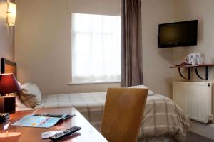um quarto de hotel com uma secretária e um sofá em Best Western Deincourt Hotel em Newark upon Trent