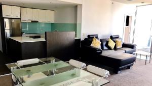 Oaks Townsville Gateway Suites في تاونزفيل: غرفة معيشة مع أريكة وطاولة
