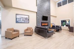 a waiting room with leather furniture and a fireplace at Super 8 by Wyndham Canmore in Canmore