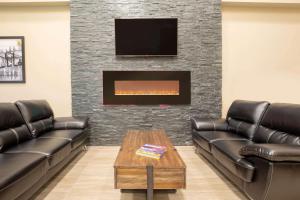 a waiting room with two leather couches and a fireplace at Super 8 by Wyndham Canmore in Canmore