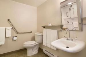 a bathroom with a white toilet and a sink at Super 8 by Wyndham Prince George in Prince George