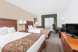 a hotel room with two beds and a flat screen tv at Baymont by Wyndham Yreka in Yreka