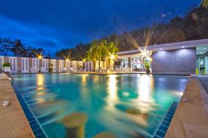 a swimming pool in a resort at night at Maikhao Home Garden Bungalow in Mai Khao Beach