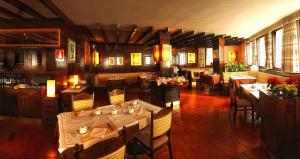 a restaurant with tables and chairs in a room at Hotel Paladin in San Martino di Castrozza