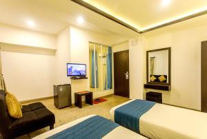 Habitación de hotel con cama y TV en Gaju Suite Hotel, en Katmandú