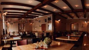 a restaurant with wooden tables and chairs in a room at Rooms Šu Šu in Karlovac