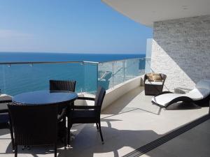 patio con mesa y sillas en el balcón en Amplio 140m2 Grand Diamond Tonsupa en Tonsupa