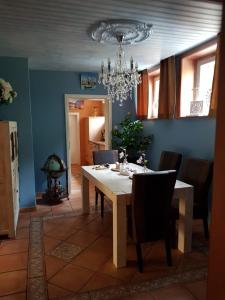 een eetkamer met een tafel en een kroonluchter bij Whirlpool Suite Venezia in Stelle