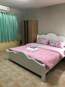 a bedroom with a bed with pink sheets and pillows at Pani House Hatyai 1 in Hat Yai