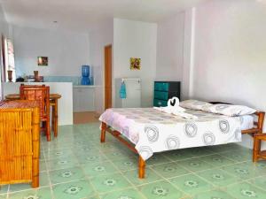 a bedroom with two beds and a kitchen at Genna's Tourist Inn Santa Fe in Bantayan Island