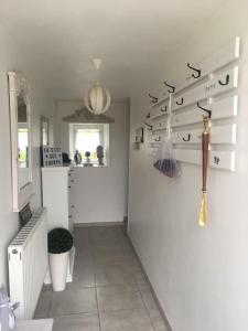 a room with a white wall with some utensils at Chambres d'Hôtes La Clef des Champs in Montpinchon