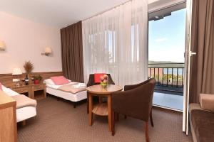 a hotel room with a bed and a table and a room at Hotel Skalny Spa Bieszczady in Polańczyk