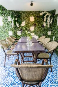 a table and chairs in front of a green wall at The LOL Elephant Hostel in Bangkok