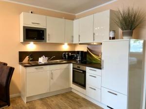 瓦倫的住宿－MÜRITZ-BRISE，厨房配有白色橱柜和白色冰箱。