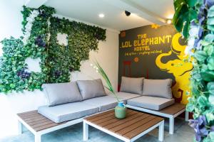 a room with two couches and a green wall at The LOL Elephant Hostel in Bangkok