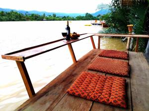 a wooden table with two mats on top of a body of water at Eden Eco Village in Kampot